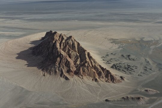 Dramatic Dark Rock Peak in a Sand Sea