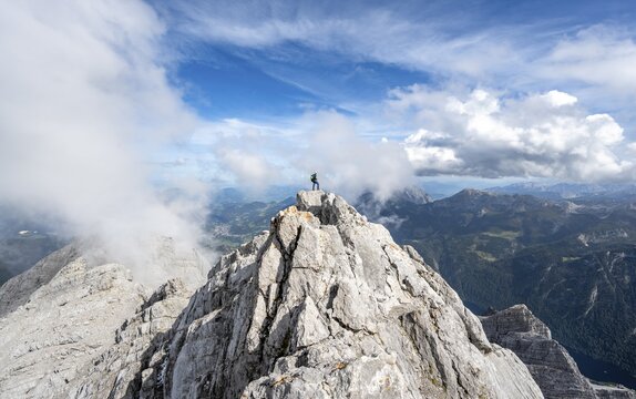Mountaineer on the rocky summit of the Watzmann Mittelspitze, Watzmann crossing, view of mountain panorama, Berchtesgaden National Park, Berchtesgaden Alps, Bavaria, Germany