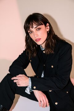Confident Woman in Stylish Black Jacket Posing Indoors with Dramatic Lighting