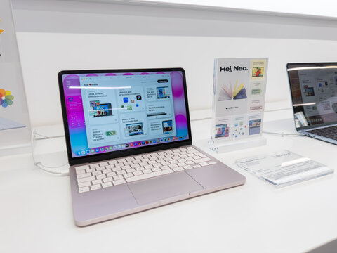 Poznan, Poland - September 19, 2026: MacBook Neo notebook computer showcased in a contemporary retail shop, featuring promotional display cards and a clean product demo setup area