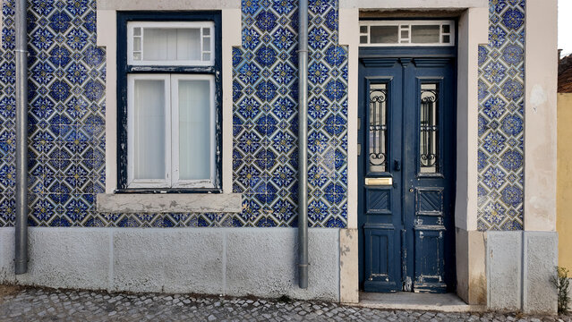 Traditional blue azulejo tiled house facade with blue door in Trafaria Portugal
