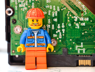 Fototapeta premium Russia, St. Petersburg, August 8, 2020 Lego figure standing next to a computer motherboard, great for tech-related illustrations