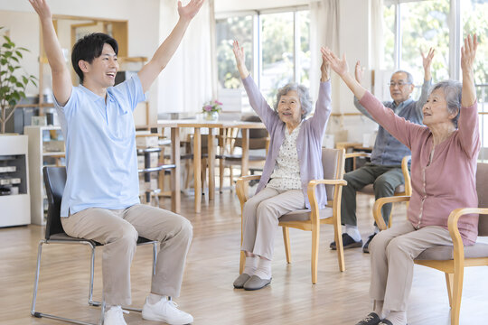Japanese care worker leading seated group exercise for older adults