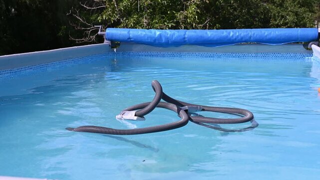 A semi-automatic underwater pool vacuum&mdash;equipped with a filter and hose&mdash;cleans sand and dirt from the pool floor.