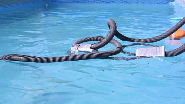 Semi-automatic underwater pool vacuum with filter and hose removing sand, dirt and debris from pool floor during cleaning