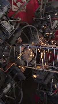 Sparks fly as a welding machine joins steel bars into a reinforcement cage at a factory