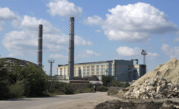 Industrial factory complex with tall chimneys against blue sky