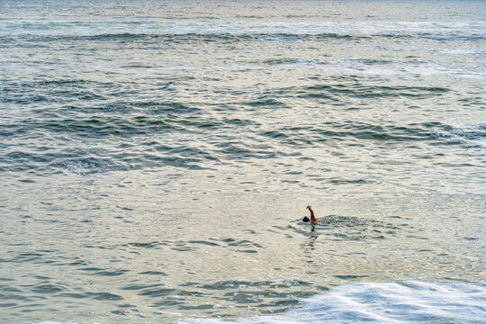 A single swimmer doing a freestyle stroke in the vast Pacific ocean open water off the coast of Miraflores, Lima.
