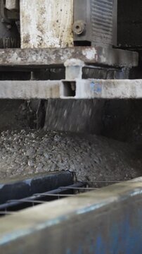 Concrete casting machine pouring fresh concrete into a steel mold at a concrete plant