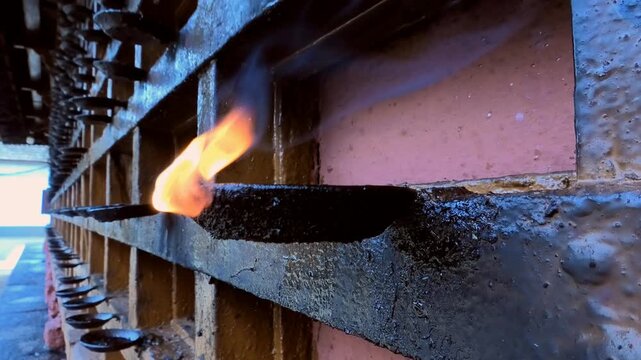 A lighted oil lamp fixed to the outer wall of a temple in Kerala, India