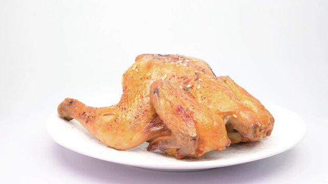 Roasted chicken rotating on white