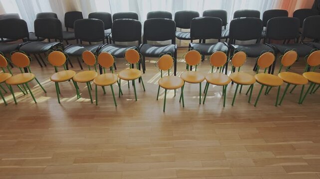 Empty classroom with chairs for adults and children facing each other. Space ready for a meeting, conference, or educational event