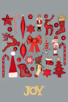 Christmas gold Joy sign with red tree bauble decorations on gray background. Festive Xmas decorative glad tidings design for holiday season.  