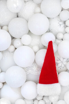 Santa hat and white Christmas sparkling tree sphere shape bauble decorations. Fun festive Xmas background for greeting card