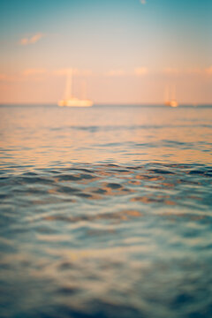Dreamy closeup pastel sunset tropical sea calm water soft glowing sky umbrella silhouette evening summer paradise vertical. Peaceful summer sunset scene nature. Romantic relaxing meditation wellness