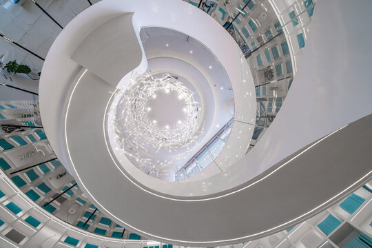 Modern architectural interior white spiral staircase shot from below looking up