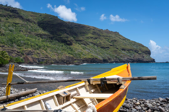 Traditional outrigger canoe on a rocky beach in Hiva Oa, Marquesas Islands