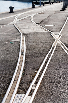 Tram tracks converge and diverge on a paved surface.