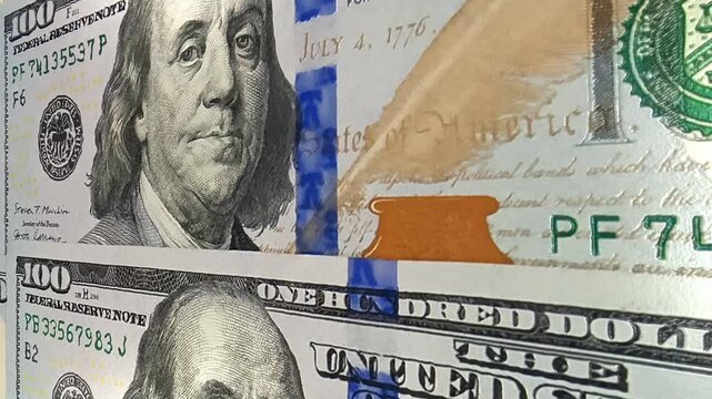 Continuous movement across detailed 100 dollar banknotes establishing an exclusive investment business setting focused on financial assets, cash flow, monetary value and economic activity