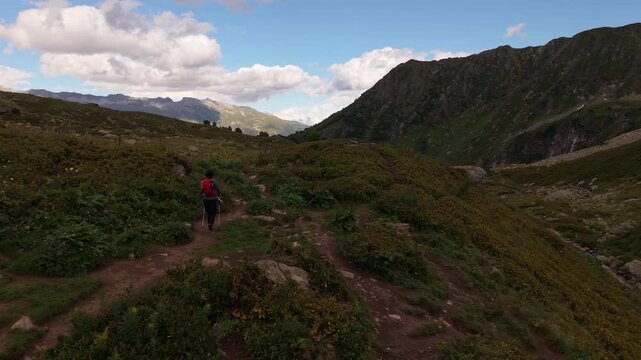 Person with red backpack hiking mountain trail