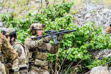 Fototapeta premium Soldiers training in a forest area, demonstrating weapon handling skills during an exercise