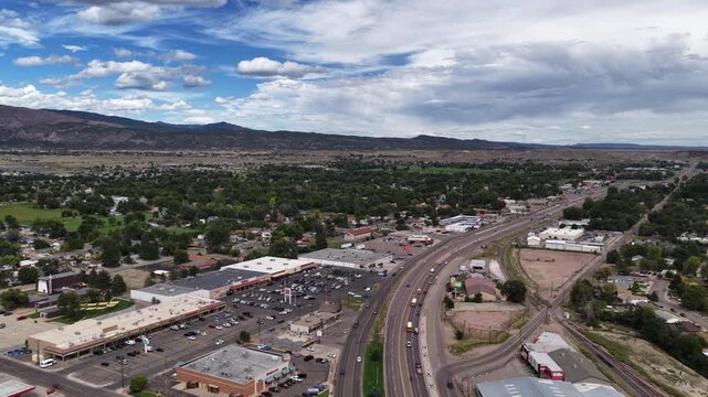 Aerial of Canon City Colorado commercial corridor and highway in summer parallel to railroad tracks