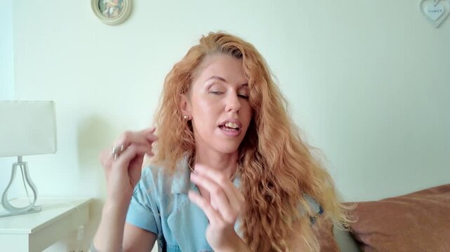 Woman Putting On Earring and Fastening It on Her Ear at Home