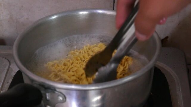 the process of cooking or boiling instant noodles in boiling water