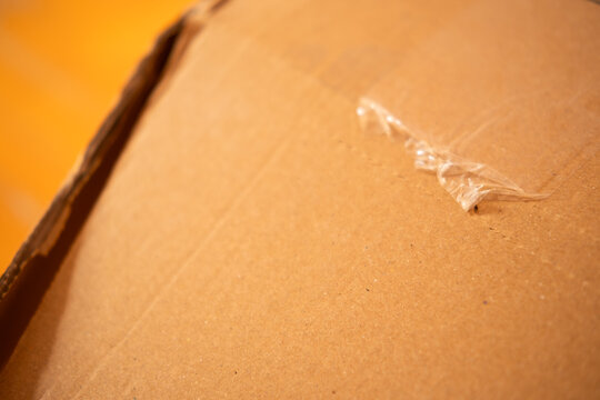 Cardboard box texture with torn adhesive tape highlighting packaging, shipping, and delivery concepts
