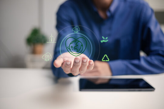 A business professional presents a digital ESG sustainability concept. The image represents carbon reduction, net zero strategy, renewable energy, recycling and corporate climate responsibility.