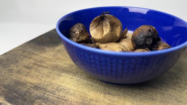Single clove garlic in blue bowl for herbal health