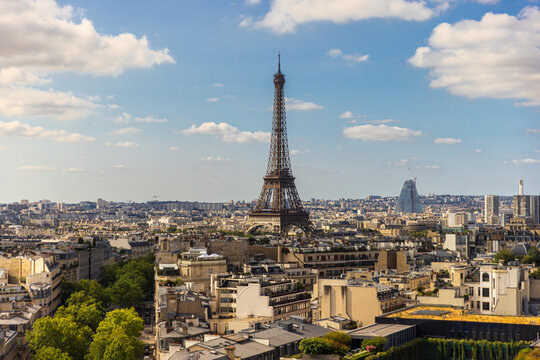 A wide, high-angle view captures the expansive Paris skyline and the iconic Eiffel Tower