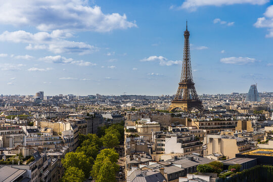 A wide, high-angle view captures the expansive Paris skyline and the iconic Eiffel Tower