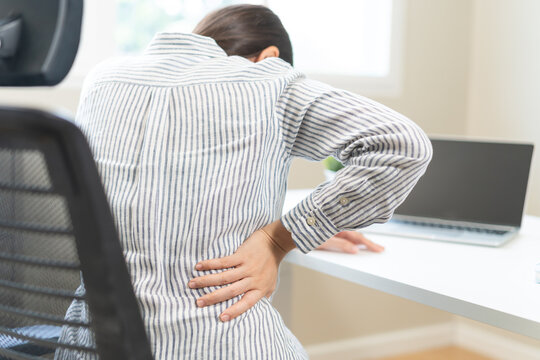 Body muscles hurt stiff, suffering asian young woman, girl back pain, body ache while sitting work at desk, hand holding massaging rubbing back, problem health care of office syndrome people concept.