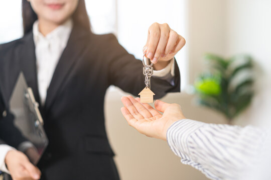 Close up agent giving a key to new owner or tenant, client after signed signature contract rental purchase, buyer apartment, home with landlord, realtor. Banker agreement mortgage loan. Property lease