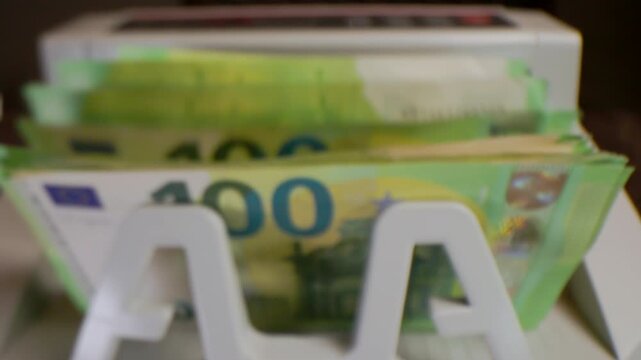 Extreme macro shot of 100 Euro banknotes in a rapid cash counting machine