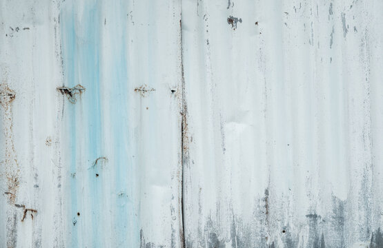 Weathered white painted galvanized metal wall texture with peeling paint and subtle rust stains, distressed industrial steel background for minimalist design and architectural surface concepts