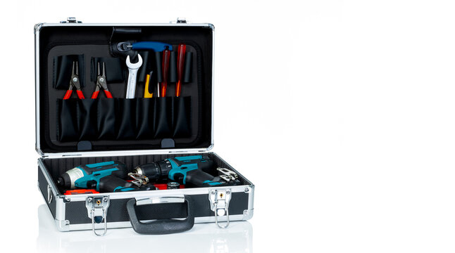 Open toolbox filled with cordless drills, pliers, wrench and screwdrivers isolated on white background, organized professional hand and power tool kit for repair, maintenance and handyman work.