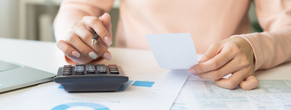 Deduction planning concept. Asian young woman hand using calculator to calculating balance prepare tax reduction income, cost budget expenses for pay money form personal Individual Income Tax Return