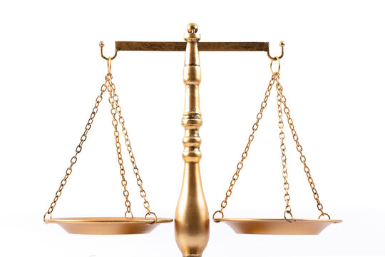 Golden equal-arm scales of justice on a white background