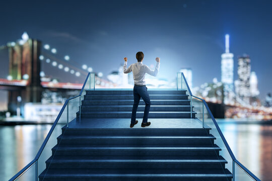 Businessman Celebrating Success on a Staircase Toward Growth, Achievement, Leadership, and Career Advancement in a Bright Corporate City Setting.