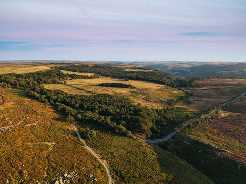 Beautiful drone landscape image view over Burbage South Edge in Peak District during Summer heather sunset