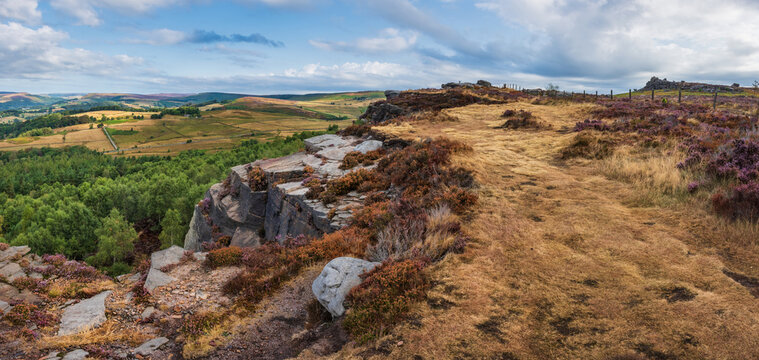 Stunning Peak District landscape from Surprise View with vibrant heather and dappled sunlight over the hills
