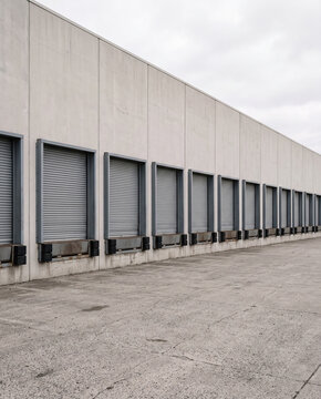 Row of loading dock bays with roller shutter doors on a warehouse exterior