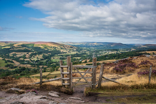 Stunning Peak District landscape from Surprise View with vibrant heather and dappled sunlight over the hills