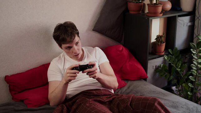 a man playing a console on the bed