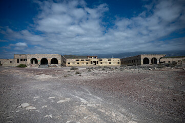 ABADES, TENERIFE, SPAIN - APRIL 24, 2025: Broad front view of the abandoned Sanatorio de Abona complex and its ruined wings. © Peter