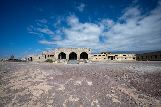 ABADES, TENERIFE, SPAIN - APRIL 24, 2025: Wide frontal view of the abandoned Sanatorio de Abona complex beneath dramatic clouds.