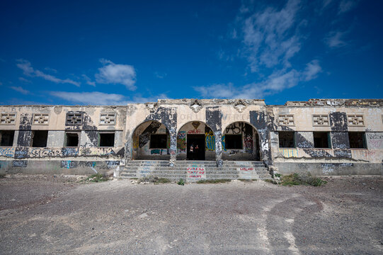 ABADES, TENERIFE, SPAIN - APRIL 24, 2025: Symmetrical main facade with arches and graffiti at the abandoned Sanatorio de Abona.