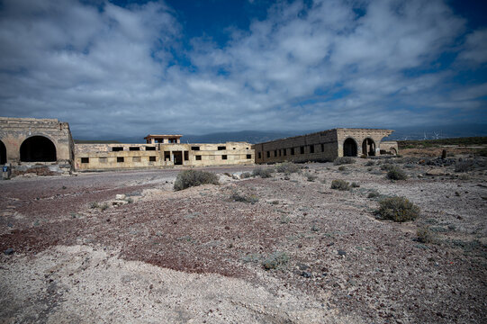 ABADES, TENERIFE, SPAIN - APRIL 24, 2025: Wide side view of the abandoned Sanatorio de Abona complex beneath dramatic clouds.